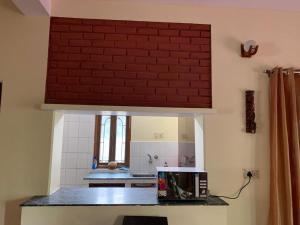 a kitchen with a brick wall above a microwave at Krimson Bricks Homestay in Varanasi +9 photos