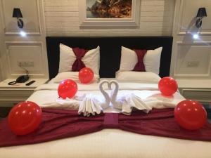 una cama con globos rojos y un cisne en ella en Best Inn Erbil - Shorash, en Erbil