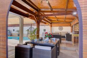 un patio con mesa, sillas y piscina en La Villa Alexie - Lagon de Trou d'Eau, en La Saline-Les-Bains