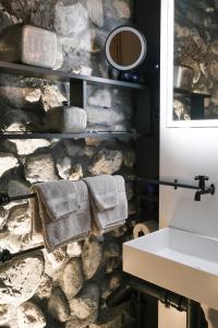 uma casa de banho com toalhas penduradas numa parede de pedra em Ferienresidenz von Planta em Pratval