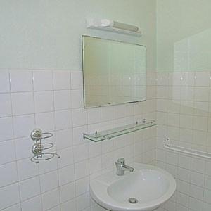 a white bathroom with a sink and a mirror at LOU FILADOUR 6 personnes 1er étage in Jausiers