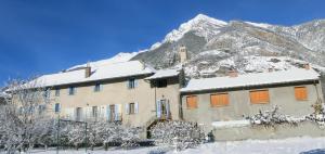 ein Gebäude vor einem schneebedeckten Berg in der Unterkunft LOU FILADOUR 6 personnes 1er étage in Jausiers