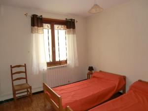 a bedroom with two beds and a chair and a window at LOU FILADOUR 6 personnes 1er étage in Jausiers