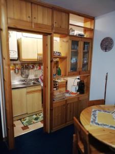 uma pequena cozinha com armários de madeira e uma mesa em CASA ILARIA em Faidello