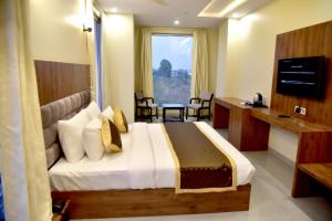 a hotel room with a bed and a window at Hotel Aarna in Jaipur