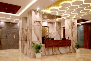 a lobby with marble walls and potted plants at Hotel Aarna in Jaipur
