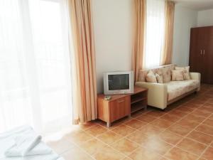a living room with a couch and a tv at Apart Hotel Kasandra in Sunny Beach