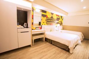 Ximen Citizen Hotel في تايبيه: غرفة فندقية بسريرين ومطبخ