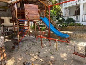 a playground with a blue slide in a yard at Rainbow Bay Beach & Dive Resort in Siquijor