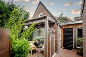 an outdoor patio with an arbor and plants at Suite-Suite luxury private guesthouse in Zandvoort