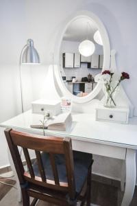 a white desk with a mirror and a vase of flowers at LION apartments - Your own apartment in Cracow in Krakow