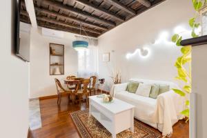 een woonkamer met een witte bank en een tafel bij Trastevere house with balcony,quiet NEW in Rome