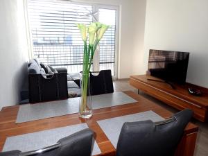 eine Vase mit Blumen auf einem Tisch im Wohnzimmer in der Unterkunft Apartment in the old town in Bratislava