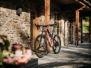 ein Fahrrad, das neben einem Steingebäude geparkt ist in der Unterkunft Die Suttenhütte in Rottach-Egern