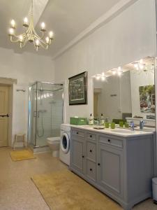 a bathroom with a sink and a washing machine at L'Enclos du Micocoulier in Boissières