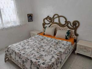 a bedroom with a bed with an ornate headboard at cozy appartement D6 in Hammamet