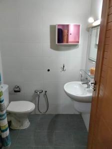 a bathroom with a toilet and a sink at cozy appartement D6 in Hammamet +7 photos