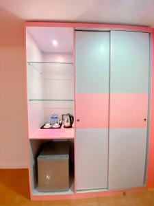 um armário rosa e branco com uma secretária em The Wai Hotel Danok em Sadao