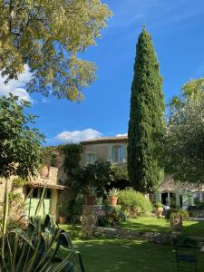 a house with a tree in the yard at L'Enclos du Micocoulier in Boissières