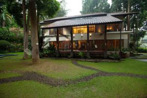 a house with a lot of windows in a yard at Villa Puncak by Plataran in Puncak