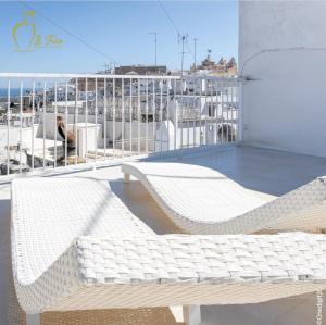 d'un balcon avec deux chaises blanches en osier sur le toit. dans l'établissement IL Fico Luxury Home Ostuni, à Ostuni