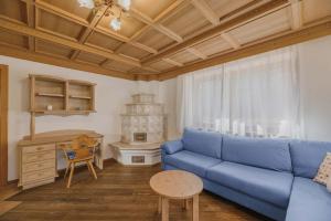 sala de estar con sofá azul y mesa en Appartamenti Cèsa Sorèie Dolomiti, en Canazei