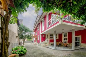 a red building with a balcony on a street at Wohnung 24 - nur 5 Minuten vom Europa-Park & Rulantica in Kappel-Grafenhausen