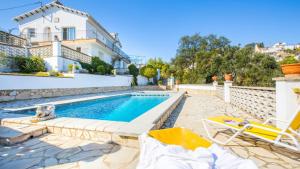 a villa with a swimming pool and two chairs at House - 3 Bedrooms with Pool and Sea views young people group not allowed - 8977 in Lloret de Mar