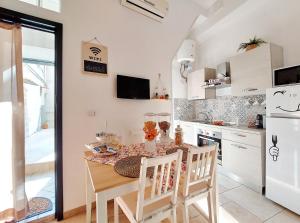 La cuisine est équipée d'une table, de chaises et d'un réfrigérateur. dans l'établissement Casa vacanze LaCorte ByFrancy, à Bari