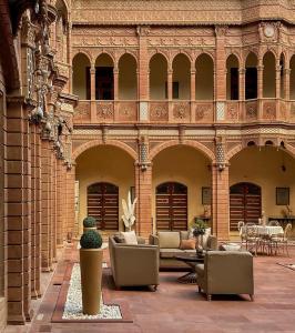 einen Innenhof mit Stühlen und einer Couch in einem Gebäude in der Unterkunft Karina art Home stay in Bikaner