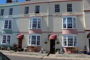 un bâtiment avec des bancs devant dans l'établissement The Redcliff, à Weymouth