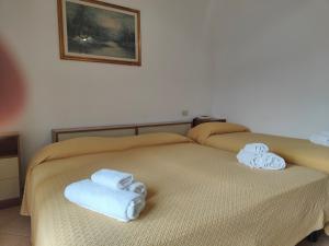 łóżko z dwoma składanymi ręcznikami na górze w obiekcie Lanterna Verde w mieście Torre Orsaia