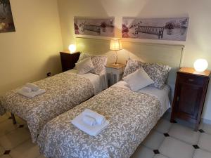 2 łóżka w pokoju hotelowym z ręcznikami w obiekcie Porta Piccola B&B w mieście Mesagne