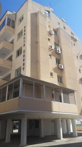 a tall building with windows on the side of it at Beautiful apartment near beach in Larnaca in Scala