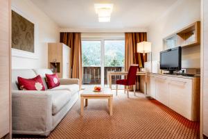 ein Wohnzimmer mit einem Sofa und einem Tisch in der Unterkunft Hotel Rita in Längenfeld