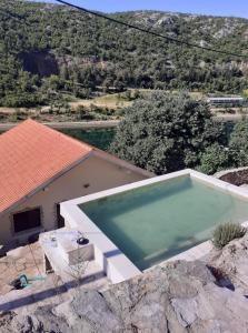 a large swimming pool sitting next to a house at VILLA ZRMANJA - 3 appartementen in Obrovac
