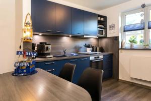 a kitchen with blue cabinets and a wooden table at Ankerhaus in Zinnowitz