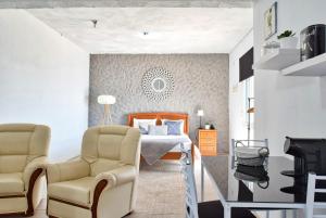 a bedroom with a bed and two chairs at Vista Mar, a Home in Madeira in Ponta do Sol