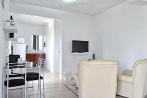 een woonkamer met een tv en een tafel en stoelen bij Vista Mar, a Home in Madeira in Ponta do Sol