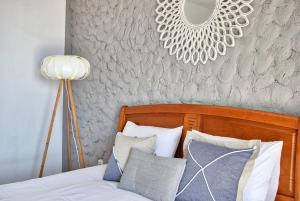 een slaapkamer met een bed met een spiegel aan de muur bij Vista Mar, a Home in Madeira in Ponta do Sol
