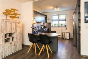 a kitchen with a counter and some black chairs at Ankerhaus in Zinnowitz