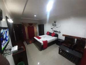 a bedroom with a bed and a flat screen tv at kurinji residency in Ooty