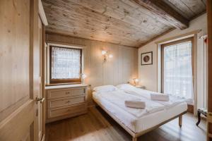 um quarto com uma cama e um tecto de madeira em Cesa Linda em Campitello di Fassa