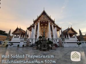 un edificio con una fuente frente a él en Non House Hostel บ้านนอนโฮสเทล en Bangkok