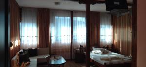 une chambre d'hôtel avec un lit, un canapé et des fenêtres dans l'établissement Hotel Ambrozia, à Kotel