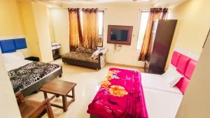 阿姆利則的住宿－Hotel Sukhman Residency，客房设有两张床、一张沙发和一台电视。