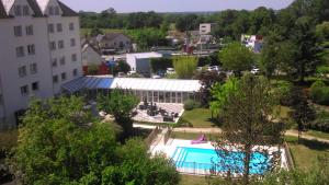 - une vue aérienne sur un bâtiment et une piscine dans l'établissement Kyriad Tours - Joué-Lès-Tours, à Joué-lès-Tours