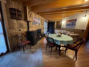 cocina y comedor con mesa y sillas en WILDHOMES Wild Wolf Lodge, en Courmayeur