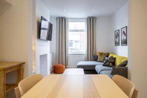 a living room with a table and a couch at Bright & Airy 2BD - 10 mins walk to Chelt Centre! in Cheltenham