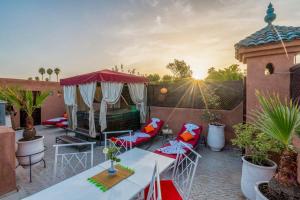 eine Terrasse mit Stühlen, einem Tisch und einem Pavillon in der Unterkunft Riad Rêves D'orient & Spa in Marrakesch